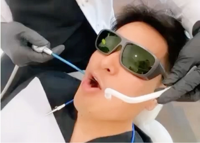 A dental patient on dental chair being worked on his teeth