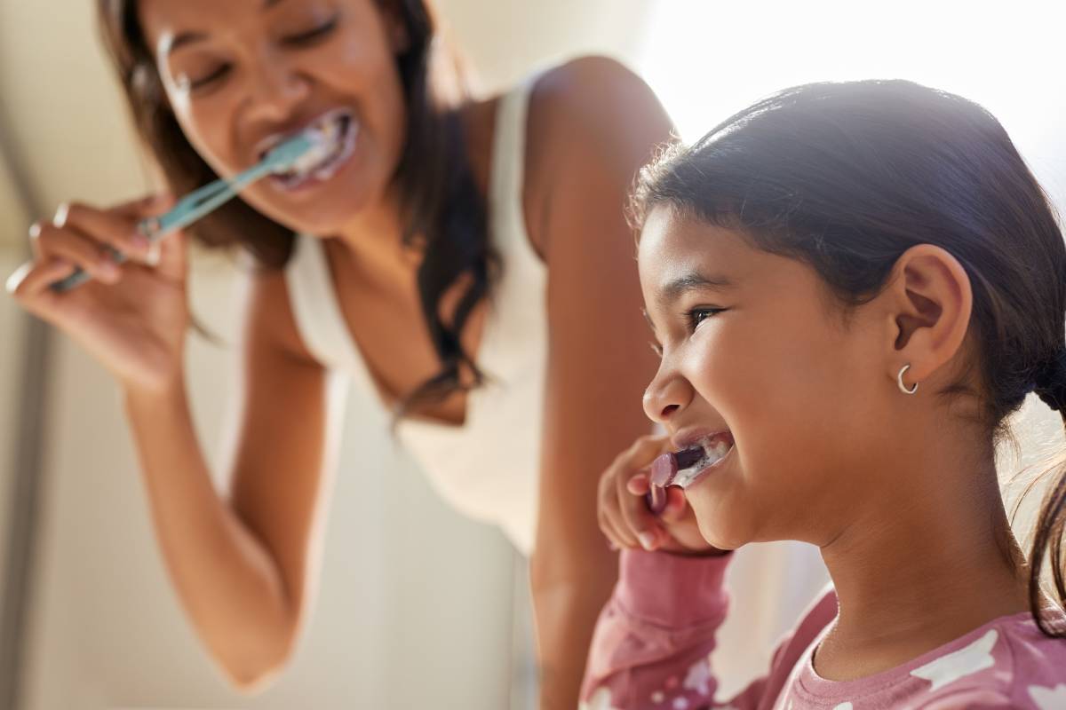 Mother and daughter brushing teeth.